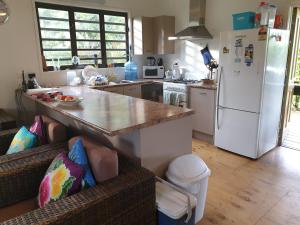 a kitchen with a counter and a white refrigerator at Eve and Sandys Holiday Home in Rarotonga