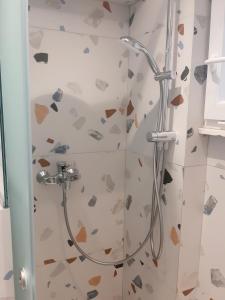 a bathroom with a shower with hearts on the wall at Vravrona Beach Apartments in Artemida
