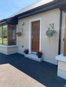 une maison avec deux plantes en pot et une porte en bois dans l'établissement Sliabh Amharc, à Laragh