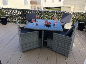 a table and chairs with wine glasses on a patio at Beautiful Spacious Holiday Home - Romney Sands in New Romney