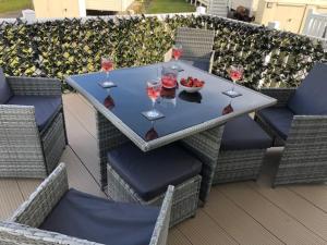 a table with wine glasses and a bowl of fruit at Beautiful Spacious Holiday Home - Romney Sands in New Romney