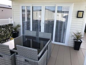 a screened in porch with a glass door at Beautiful Spacious Holiday Home - Romney Sands in New Romney