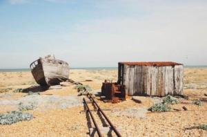 an old boat and a shed on a beach at Beautiful Spacious Holiday Home - Romney Sands in New Romney