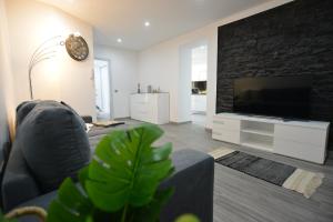 a living room with a couch and a flat screen tv at Casas do Baleeiro - Whaler's Houses in Caniçal