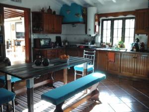 a kitchen with a wooden table and blue chairs at Casa Uldina in Bombarral