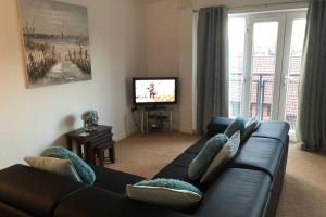 un salon avec un canapé et une télévision dans l'établissement Liverpool, Superb City Centre Apartment With Parking, à Liverpool