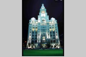 un grand bâtiment avec une tour d'horloge la nuit dans l'établissement Liverpool, Superb City Centre Apartment With Parking, à Liverpool