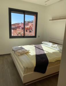 a bedroom with a large bed with a window at Holiday signature in Marrakech