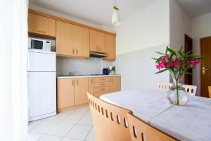 eine Küche mit einem Tisch und einer Blumenvase darauf in der Unterkunft Apartments Zlatko - 100m from sea in Donje Selo
