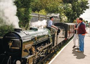 a group of people looking at a small train at Beautiful Spacious Holiday Home - Romney Sands in New Romney