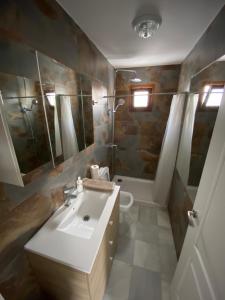 een badkamer met een wastafel, een toilet en een bad bij SPIRIT GARDEN Tarifa in Tarifa