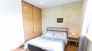 a small bedroom with a bed and a night stand at La Découverte, Jacuzzi, Sauna, et Terrasse avec vue sur lac à la campagne entre Toulouse et Auch in Catonvielle