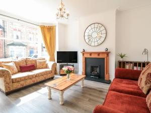 a living room with two couches and a fireplace at The Robins in Filey