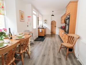 a kitchen with wooden floors and a table and chairs at The Robins in Filey