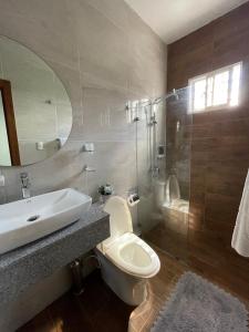 y baño con lavabo, aseo y espejo. en Hotel Monarca, en Higüey
