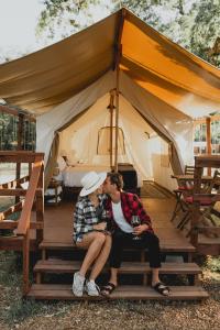a woman sitting on top of a wooden bench at Wildhaven Sonoma Glamping in Healdsburg