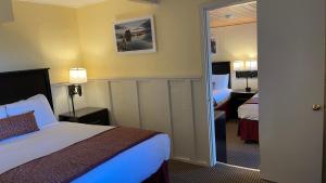 ein Hotelzimmer mit einem Bett und einem Spiegel in der Unterkunft Yosemite Gateway Motel in Lee Vining