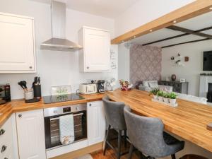 a kitchen with white cabinets and a wooden counter top at Martingale in Torquay