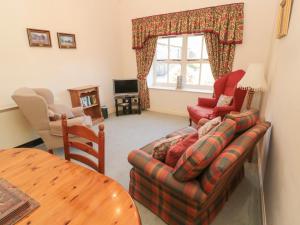 a living room with a couch and a table at Pansy Plot in Wooler