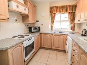 a kitchen with wooden cabinets and a stove top oven at Pansy Plot in Wooler