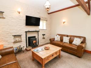a living room with a couch and a fireplace at Shepherd's Cottage in Newbiggin