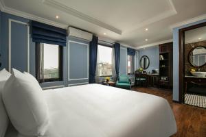 a bedroom with a large white bed and a bathroom at Romantique Hotel De Hanoi in Hanoi