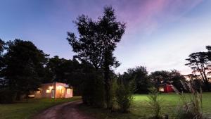 a house in a field next to a dirt road at NomeolvidesMás in Tandil