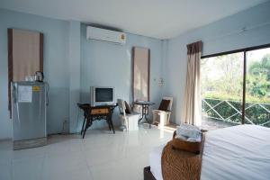 una camera da letto con un letto, una televisione e una finestra di Long Lake Resort a Ban Nong Pru