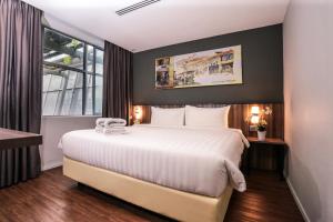um quarto de hotel com uma cama grande e uma janela em Days Hotel & Suites by Wyndham Fraser Business Park KL em Kuala Lumpur