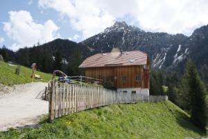 una casa de madera en una colina con una valla en Le Maier, en San Vigilio Di Marebbe