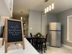 a kitchen with a table and a chalkboard in a kitchen at The Roulette Duplex- With Private Yard & Parking, Minutes From Falls & Casino by Niagara Hospitality in Niagara Falls