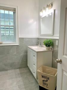 a white bathroom with a sink and a window at The Maid of the Mist Villa- With Private Yard & Parking, Minutes From Falls & Casino by Niagara Hospitality in Niagara Falls