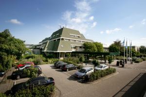 um parque de estacionamento com carros estacionados em frente a um edifício em Van der Valk Hotel Vianen - Utrecht em Vianen