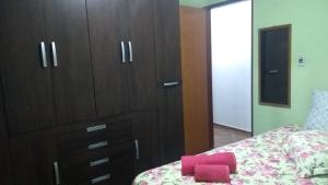 1 dormitorio con tocador y 1 cama con toallas rosas en Hospedagem Colinas, en Aiuruoca