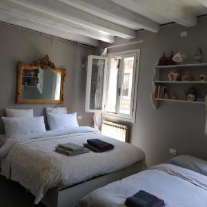 a bedroom with two beds and a mirror on the wall at Rio Marin Apartment Gondola View & Patio in Venice