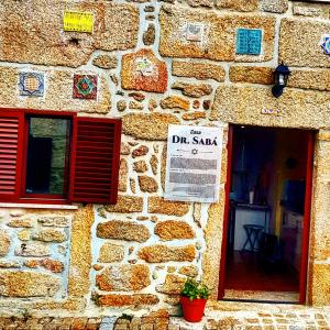 un edificio de piedra con una ventana y un cartel en él en Casa Dr. Saba en Belmonte