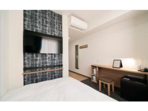 a hotel room with a bed and a desk and a desk at R&B Hotel Nagoya Ekimae - Vacation STAY 15184v in Nagoya