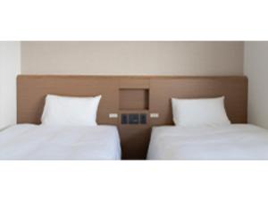 2 letti posti uno accanto all'altro in una stanza di R&B Hotel Nagoya Ekimae - Vacation STAY 15188v a Nagoya