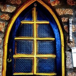 une porte bleue et or dans un bâtiment dans l'établissement Dona Gracia Belmonte, à Belmonte