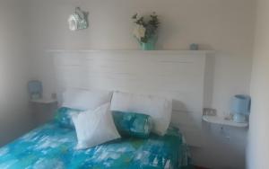 een bed met blauwe en witte kussens erop bij La casina in Capoliveri