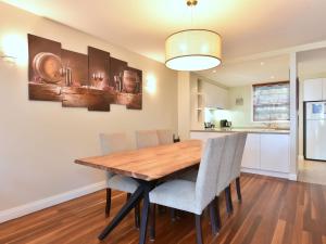 a kitchen and dining room with a wooden table and chairs at Villa 3br Vista Villa located within Cypress Lakes Resort in Pokolbin