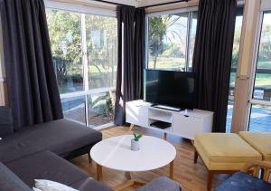 NRMA Shellharbour Beachside Holiday Park في شلهاربور: غرفة معيشة مع أريكة وتلفزيون