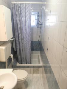 a bathroom with a toilet and a sink and a shower at Kenzo apartment in Senj