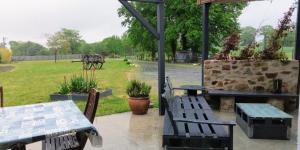 a patio with tables and benches and a horse drawn carriage at La chambre du Clos Barriant in Séreilhac