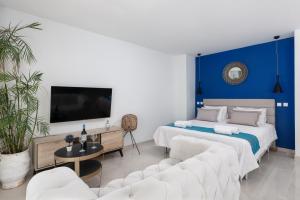 a bedroom with two beds and a blue accent wall at Bamboo Suites Hotel in Ialyssos