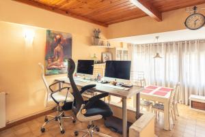 una oficina con un escritorio con dos monitores y una silla en Apartamento "El Lilà 3" - Parking incluido, en Platja d'Aro