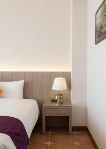 a bedroom with a bed and a table with a lamp at Kending Kaying Hotel in Hengchun South Gate