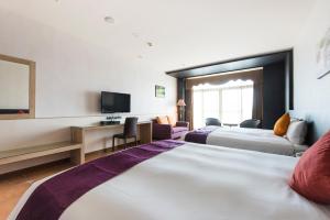 Łóżko lub łóżka w pokoju w obiekcie Kending Kaying Hotel