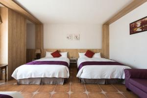 Łóżko lub łóżka w pokoju w obiekcie Kending Kaying Hotel