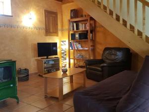 ein Wohnzimmer mit einem Sofa und einem TV in der Unterkunft Gîte Villemontais, 4 pièces, 6 personnes - FR-1-496-121 in Villemontais